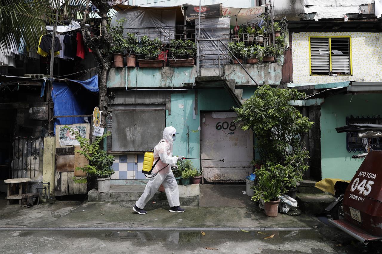 A man wearing a protective suit disinfects an area placed under stricter lockdown measures to curb the spread of Covid-19 in Caloocan City, Philippines on Aug. 14, 2020.
(AP Photo/Aaron Favila)