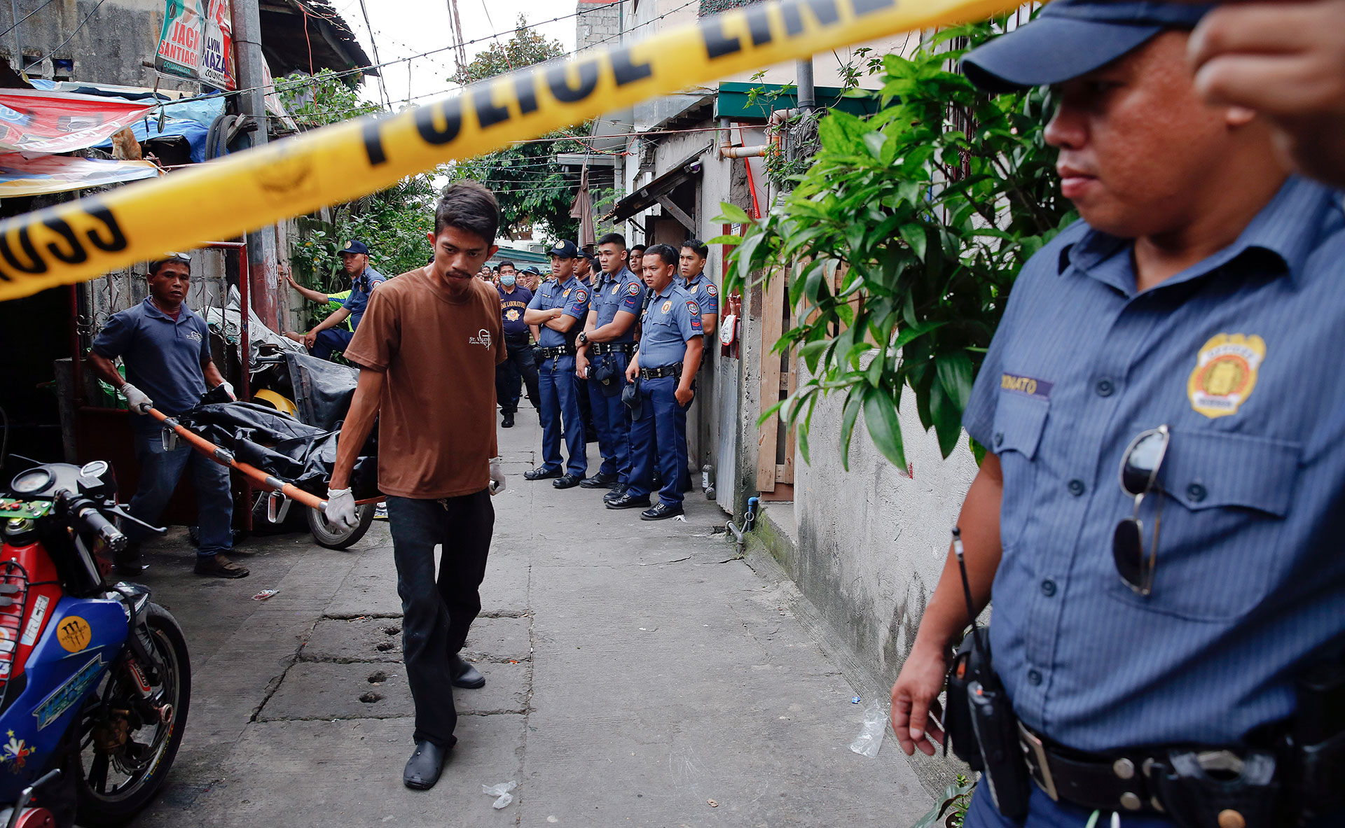 Funeral workers carry the bodies of pedicab drivers Norberto Maderal and George Avanceña. Police say the men were shot dead after trying to open fire on officers. Maderal’s nephew said his uncle was unarmed and begging for his life before the police fired. (REUTERS/Damir Sagolj)